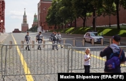 Люди у шлагбаума на Красной площади в Москве 25 июня