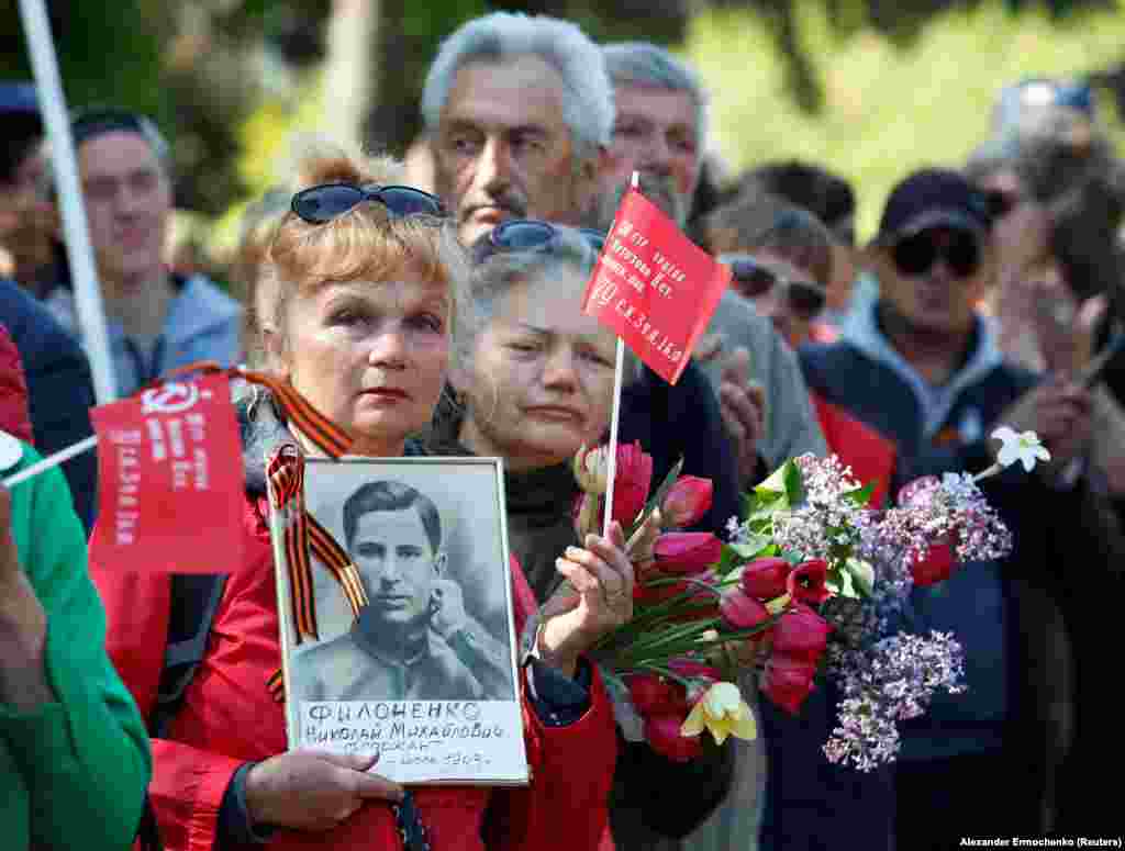 Женщина с портретом красноармейца во время празднования Дня Победы