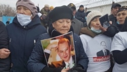 Активистка стоит с портретом Мухтара Джакишева у ворот колонии. Семей, 19 марта 2020 года.