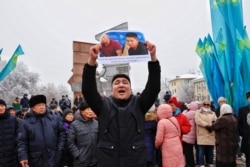 Участник митинга с плакатом в Алматы, 16 декабря 2019 года.