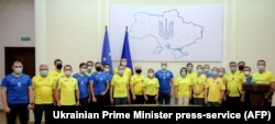 Прем'єр-міністр Денис Шмигаль та члени його уряду позують у футболках національної збірної України з футболу під час засідання Кабінету міністрів. Київ, 30 червня 2021року