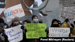 Протестующие держат плакаты во время митинга оппозиции в День независимости Казахстана. Алматы, 16 декабря 2020 года.