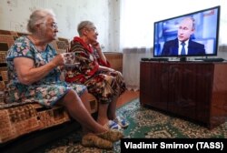 Жительницы села Ельна смотрят трансляцию пресс-конференции Владимира Путина, июнь 2018 года.