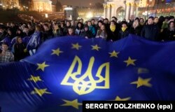 Украинцы держат флаг Евросоюза во второй день акции протеста на площади Независимости в центре Киева, 22 ноября 2013 года.