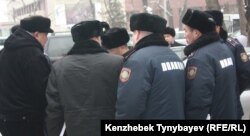 Полицейские стоят перед Национальным пресс-клубом в момент когда оппозиционным политикам вручают повестки в административный суд. Алматы, 30 января 2012 года.