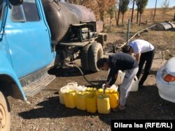 Жители Акжара набирают воду из «общего» колодца.