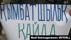 Плакат, продемонстрированный группой пенсионеров на акции протеста у здания центра по выплате пенсий. Алматы, 2 марта 2011 года.