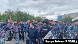 Полицейские идут в сторону собравшихся на протест. Нур-Султан, 9 июня 2019 года.