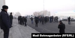 Полицейский наблюдает за участниками акции протеста против девальвации тенге. Алматы, 12 февраля 2014 года.