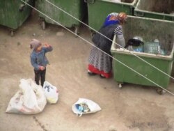 Женщина и мальчик собирают пластиковые бутылки в Ашгабате. 16 января 2014 года.