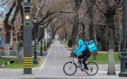 Курьер службы доставки едет по улице Алматы. Иллюстративное фото. 28 марта 2020 года.