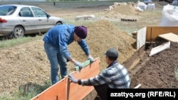 Мужчины ставят опалубку для заливки фундамента дома в селе Курайлы. Актюбинская область, 4 июня 2017 года.