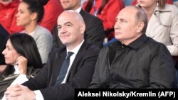 Vladimir Putin (sağda) və FIFA prezidenti Gianni Infantino Moskvada qala konsertdə, 13 iyun, 2018-ci il