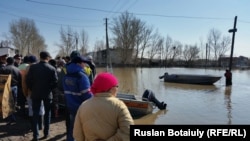 Жители села Оразак рядом с лодками спасателей ждут, когда их смогут переправить к домам, чтобы забрать вещи. Акмолинская область, 29 апреля 2015 года.