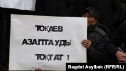 Участник митинга в Алматы с плакатом, призывающим власти Казахстана остановить пытки