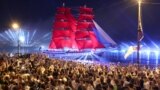 ST PETERSBURG, RUSSIA – JUNE 26, 2021: Young people look at the Rossiya brig on the Neva River during the Scarlet Sails (Alye Parusa) festival